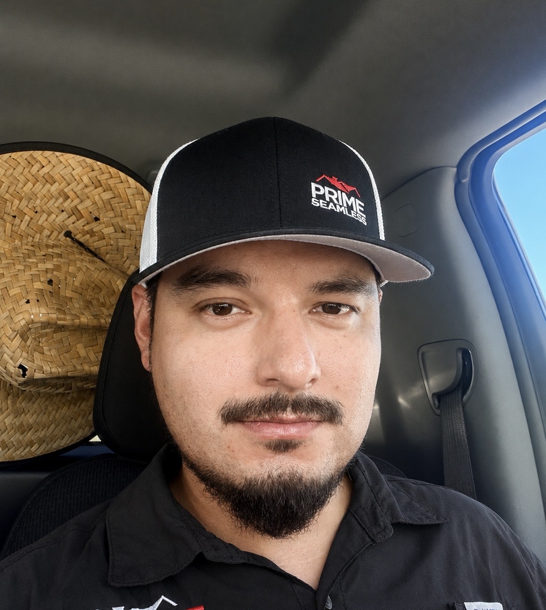 Man wearing Prime Seamless Gutters cap and black shirt in vehicle, San Antonio roofing and gutter contractor